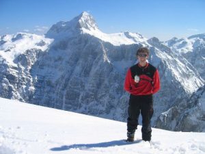 Christoph am Gipfel mit der Triglav Nordwand im Hintergrund
