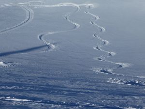 Spuren im Schnee von Abfahrt und Wiederanstieg