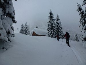 Aufstieg vorbei an der tief verschneiten Jagdhütte